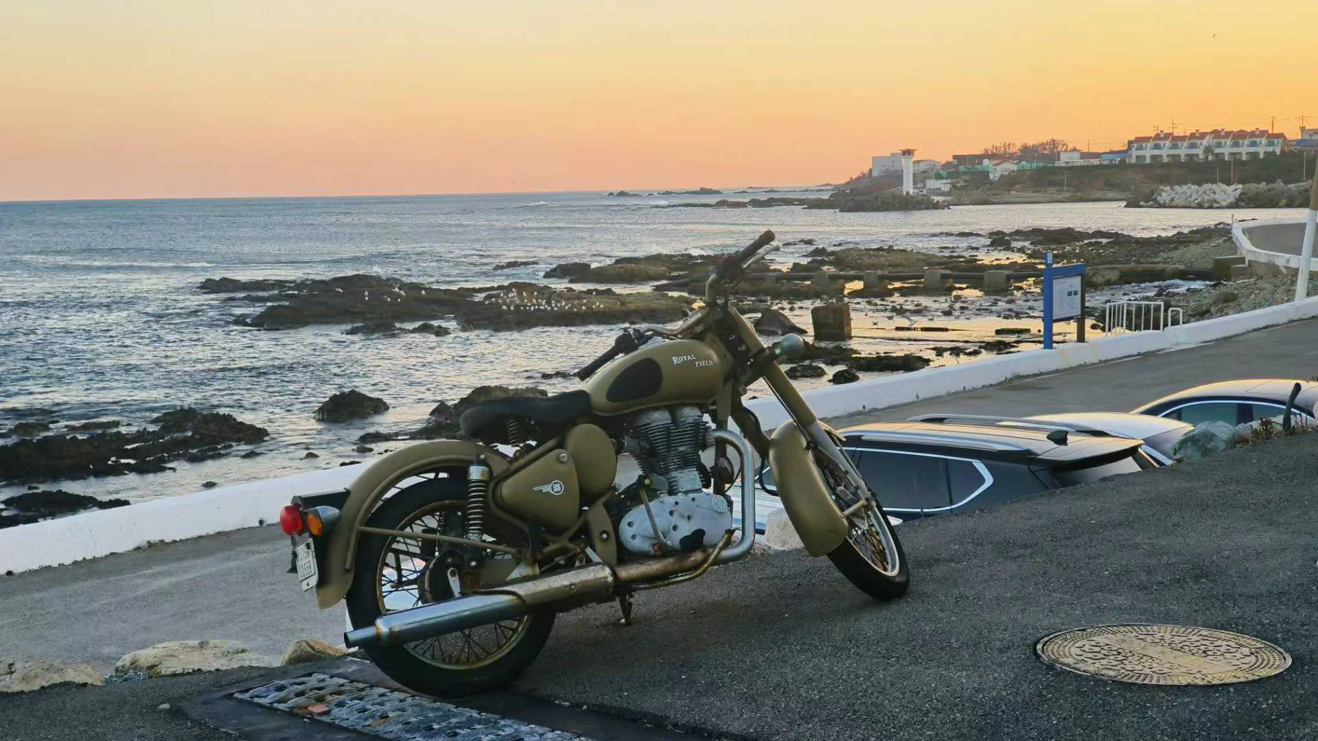 A motorcycle beside the sea at sunset